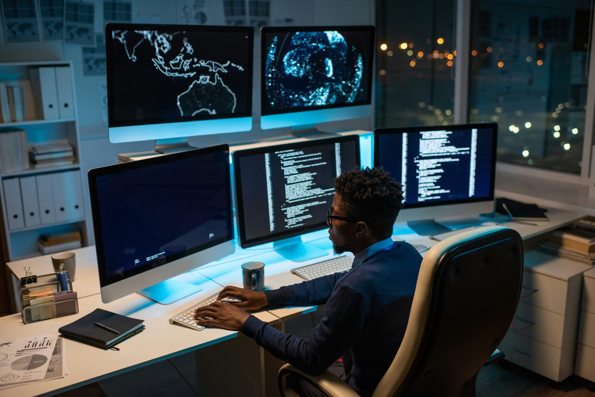 Engineer working at a desk with multiple monitors