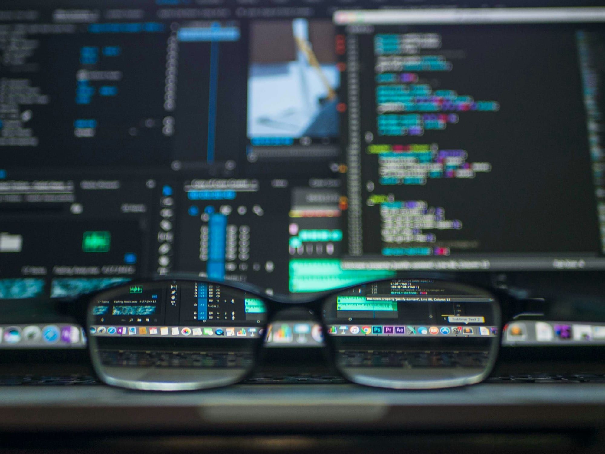Glasses in front of screens full of code