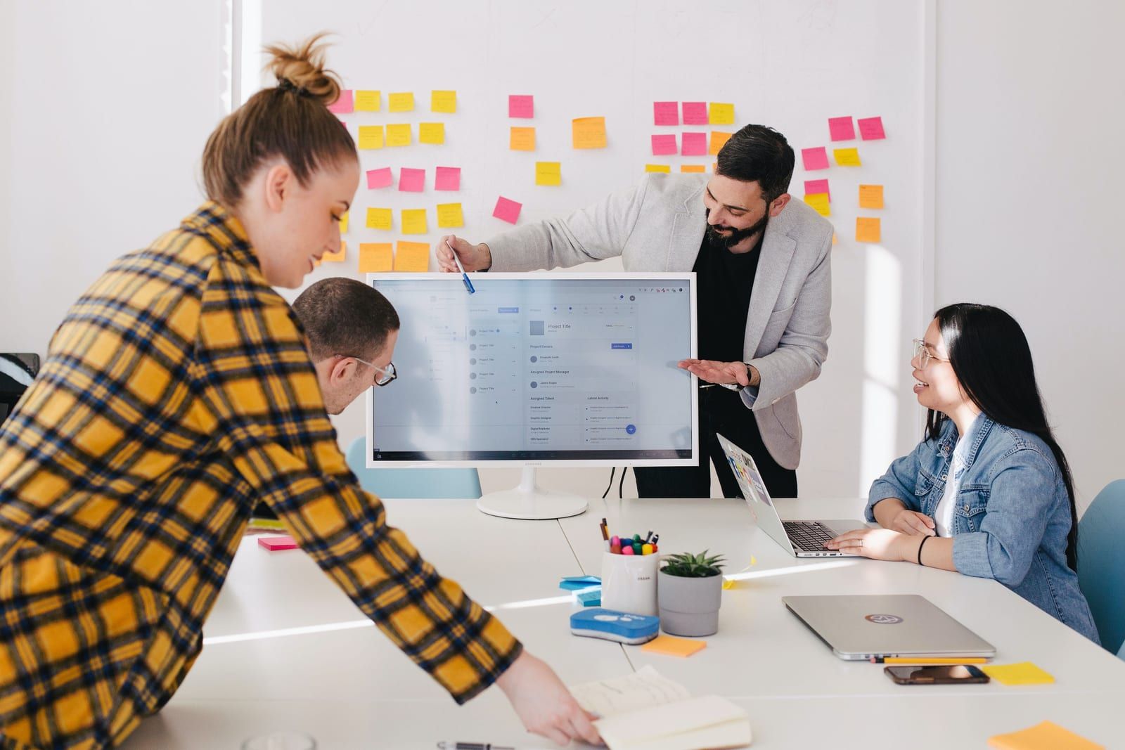 Team workshop around a whiteboard covered in sticky notes